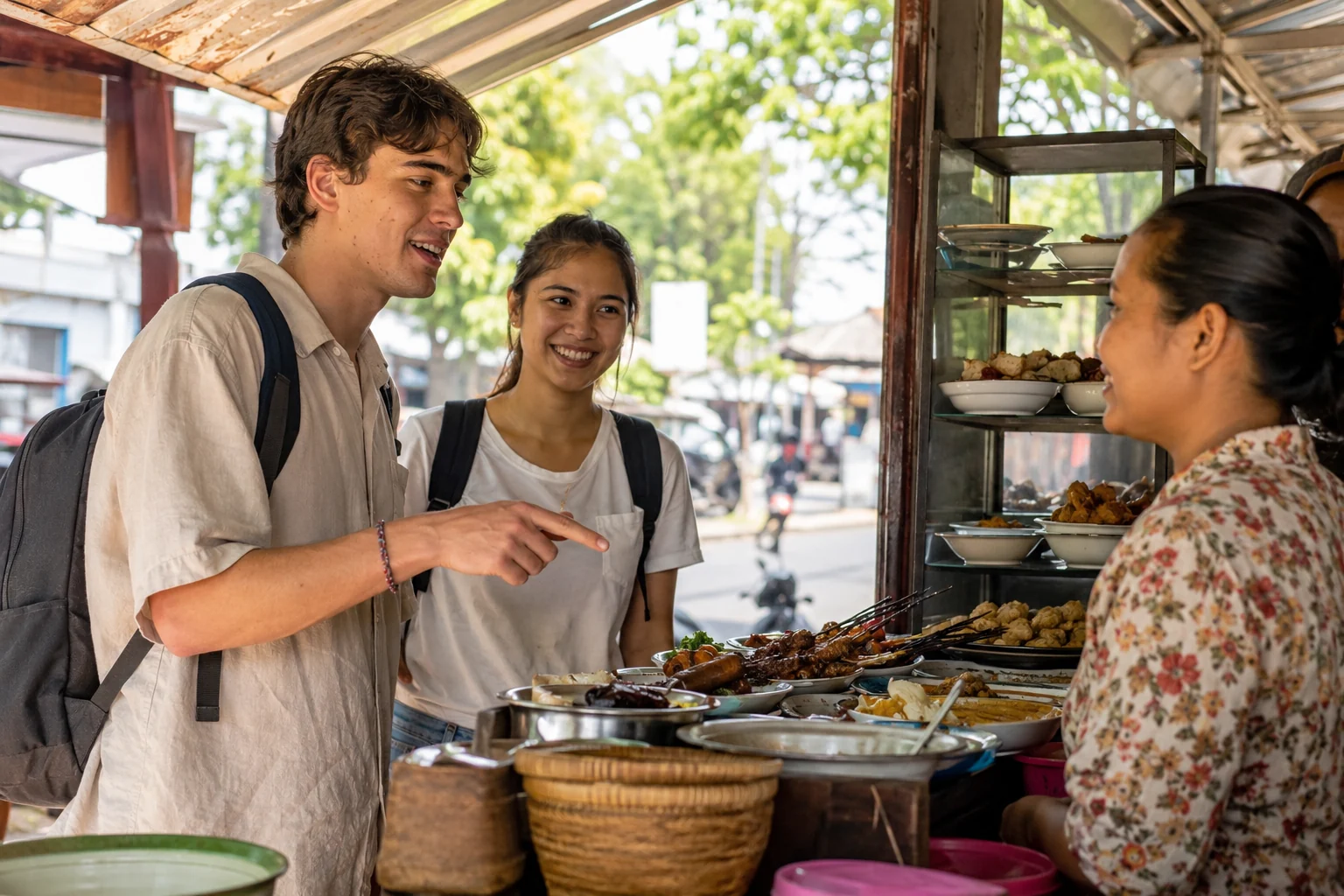 An international student orders food in Bahasa Indonesia with support from an Indonesian peer at a welcoming local warung.
