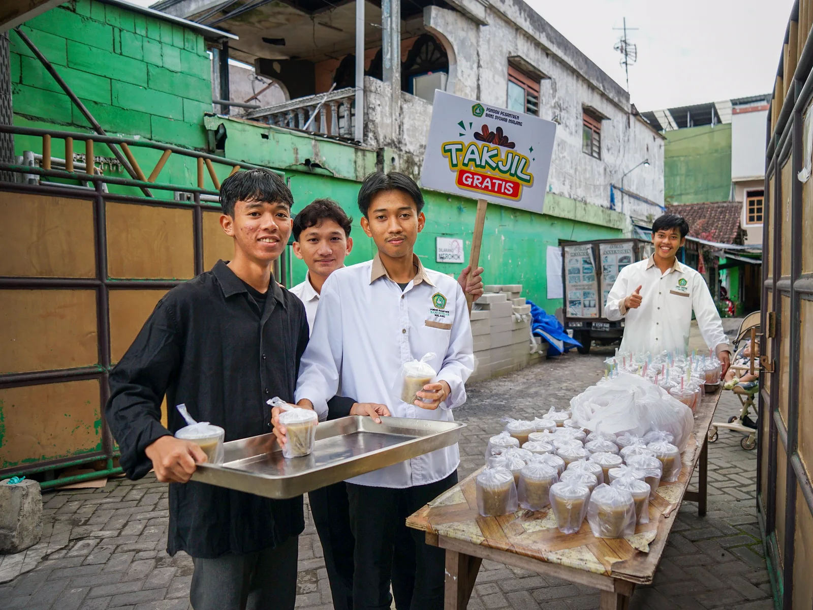 Young volunteers share free takjil in an Indonesian neighborhood.