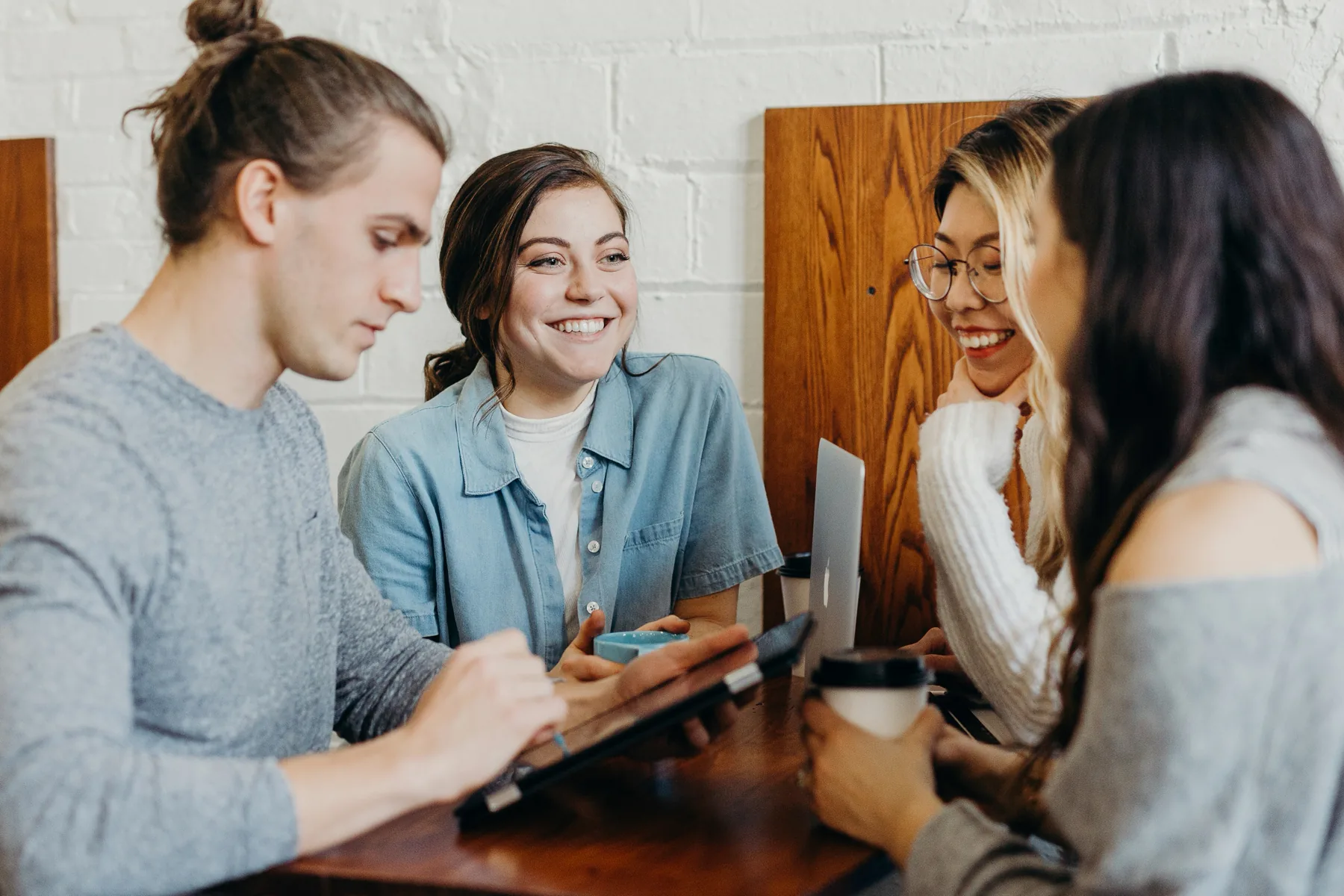 Four students share a conversation around a table.